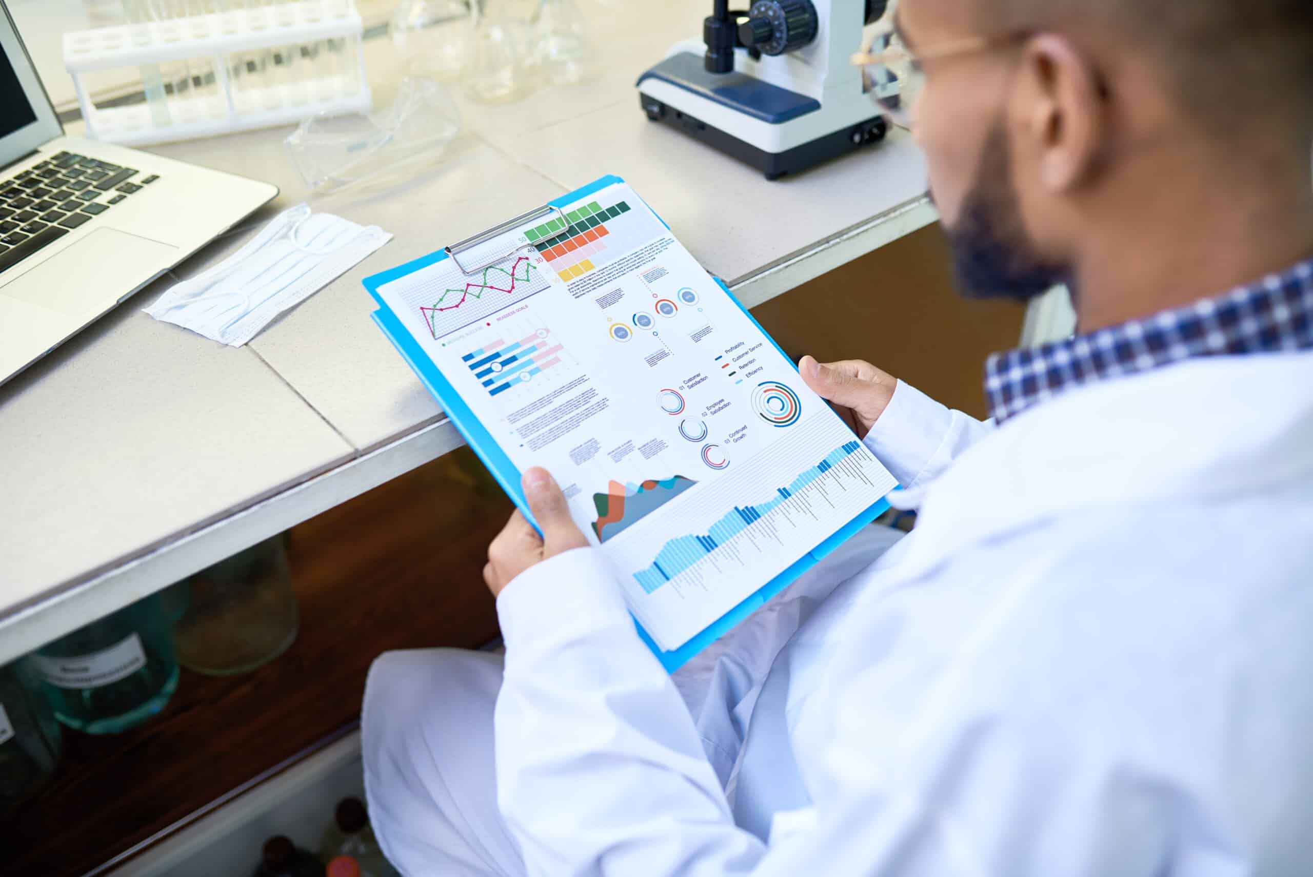 Scientist reviewing data analytics report with charts and graphs